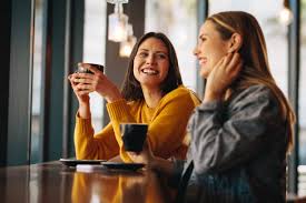 Two people holding coffee cups across table close up