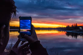 Person looking at phone with sunset in background
